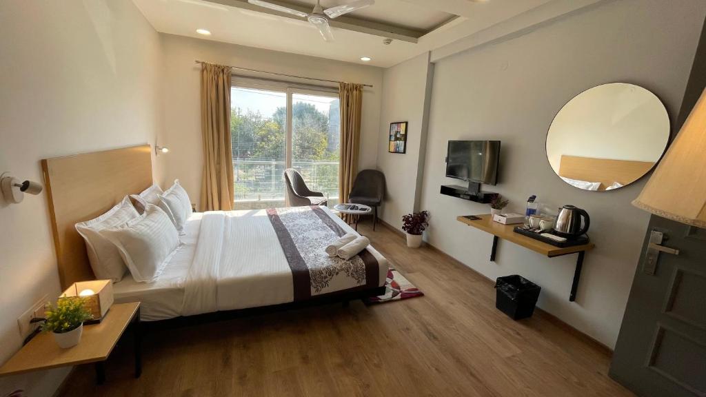 Habitación de hotel con cama y espejo en Saltstayz Sector 39 - Near Medanta Hospital, en Gurgaon