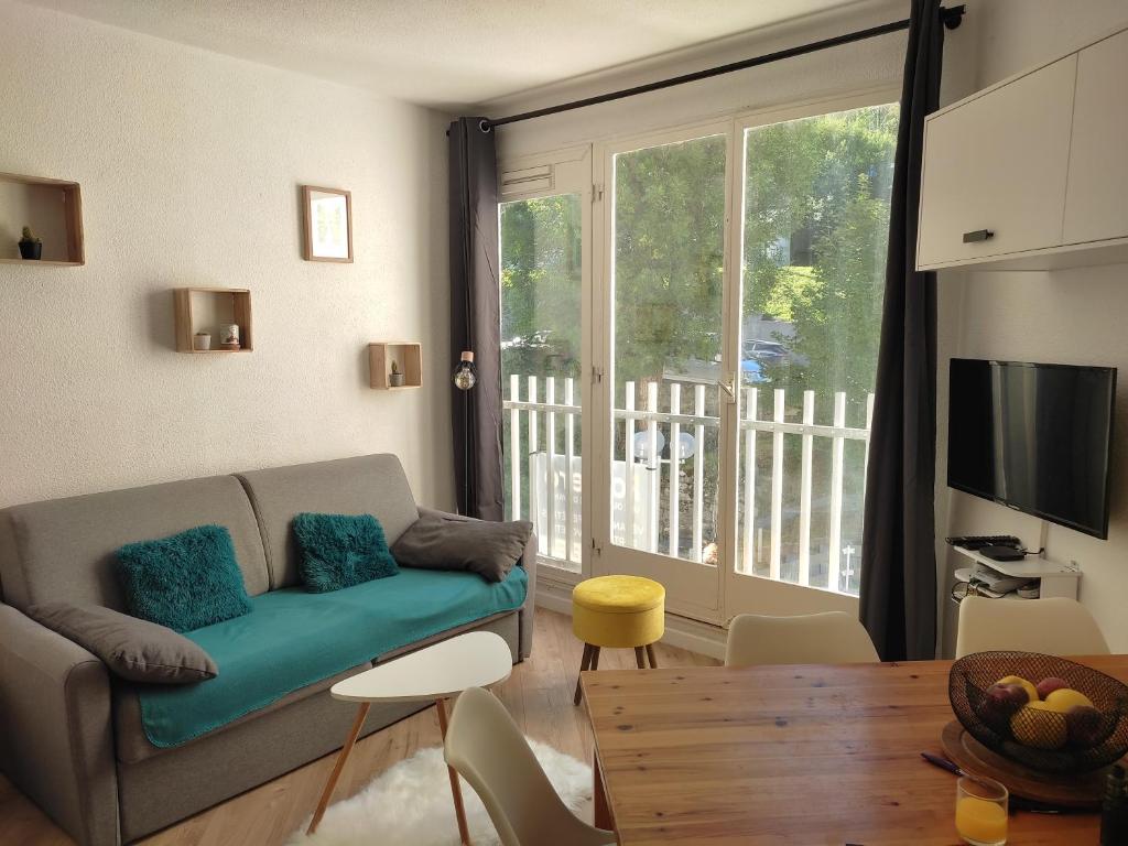 salon z kanapą i stołem w obiekcie Beau T2 rénové en 2023 pour 5-6 personnes à Barèges w mieście Barèges