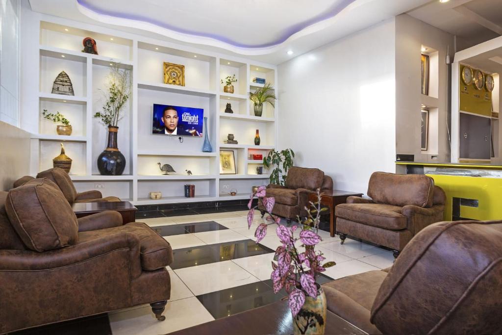 uma sala de espera com sofás e uma televisão em Mashpark Apartments em Nairobi