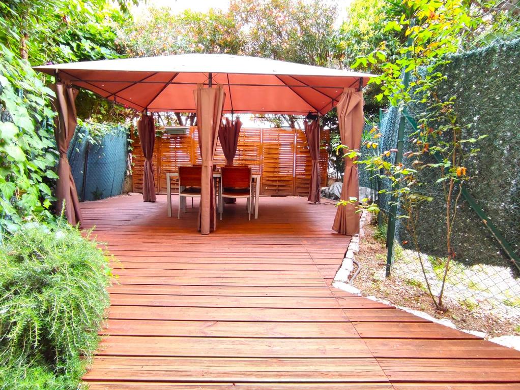 - une passerelle en bois avec un parasol dans le jardin dans l'établissement GARDEN LEVEL nearby beach, à Nice
