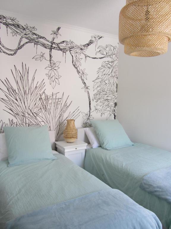 - une chambre avec 2 lits et une fresque murale sur les arbres dans l'établissement Appartement Les Cigales Rez de Jardin à 10mn des plus belles plages, à Hyères