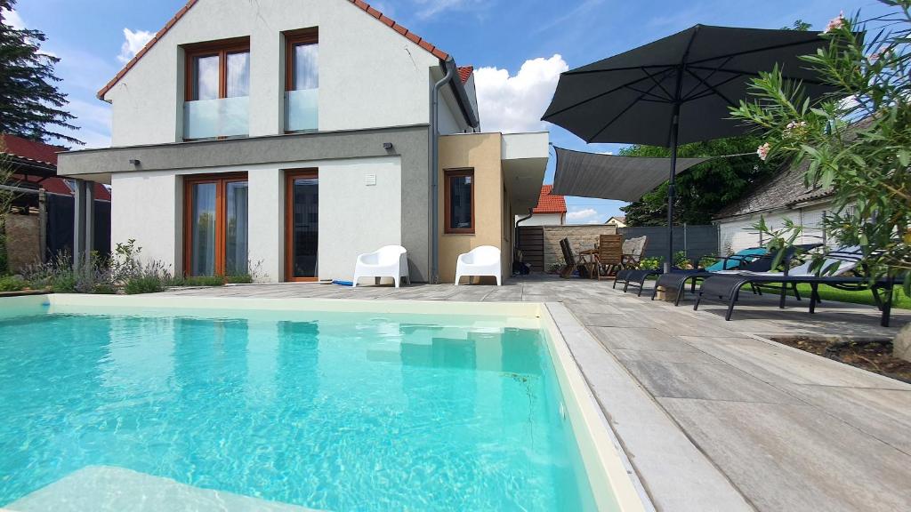 a house with a swimming pool in front of a house at Velence Lakeside Pool House in Velence