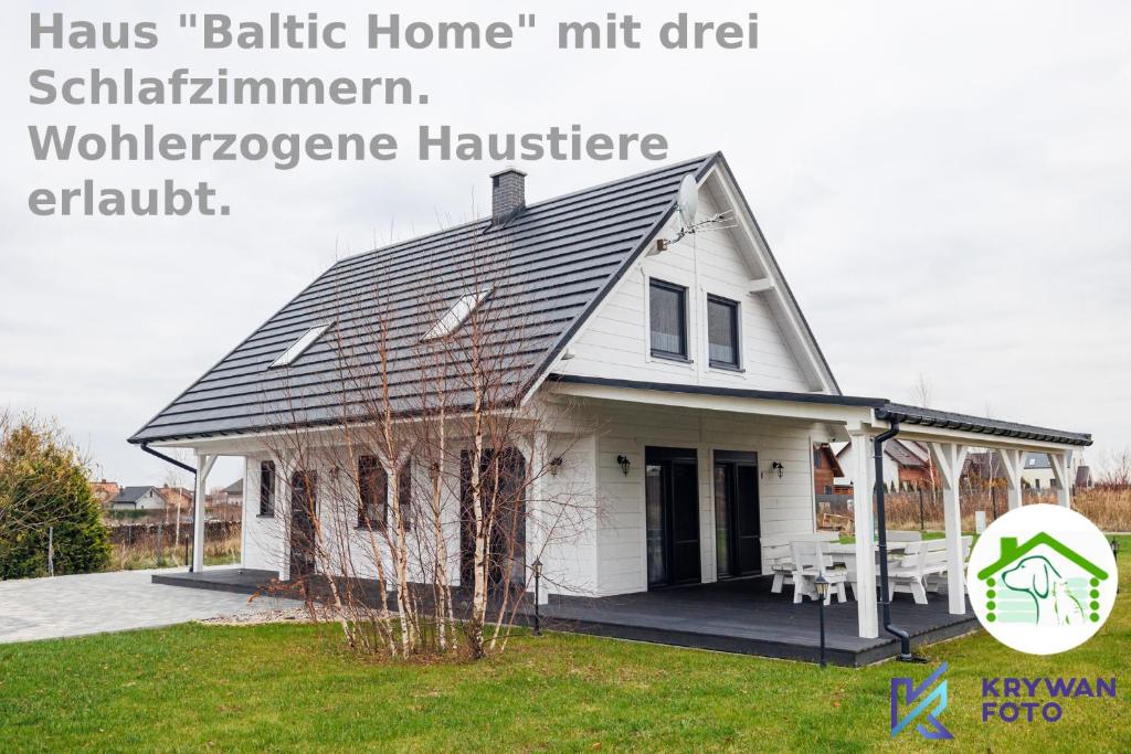 a white house with a porch and a sign that reads hasmt at Dom Wakacyjny Baltic Home & Dom Baltic Home Garden Inn in Zastań