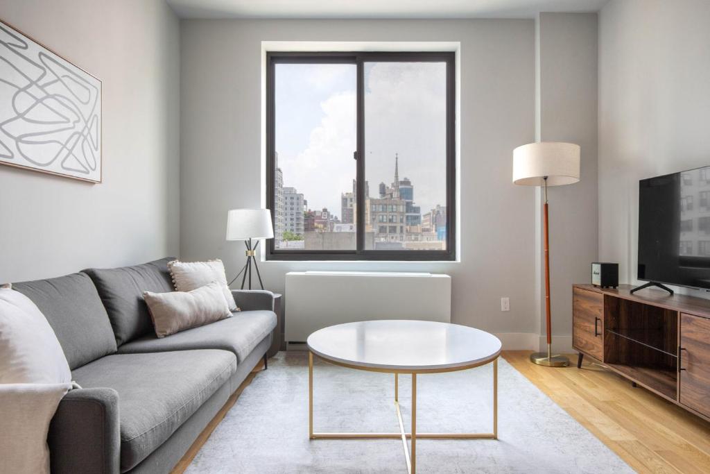 un soggiorno con divano e tavolo di East Village 2br w doorman wd nr Union Square NYC-1185 a New York