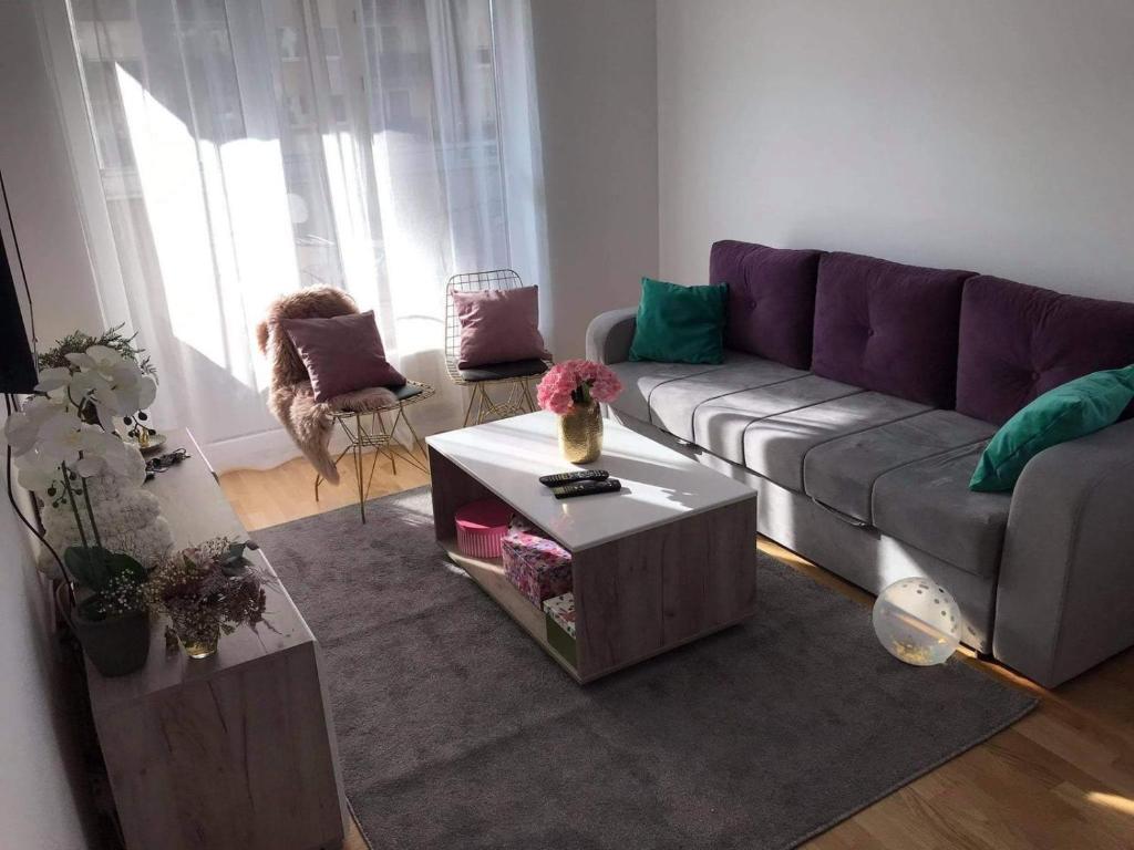 a living room with a purple couch and a table at Luxury apartments - Otoka Sarajevo in Sarajevo