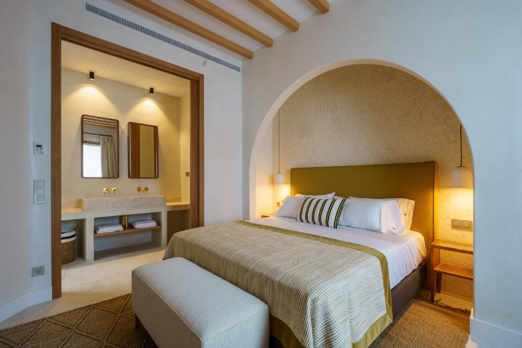 a bedroom with a bed and a bathroom with a sink at Cortijo Boutique Siete Calas in Rodalquilar