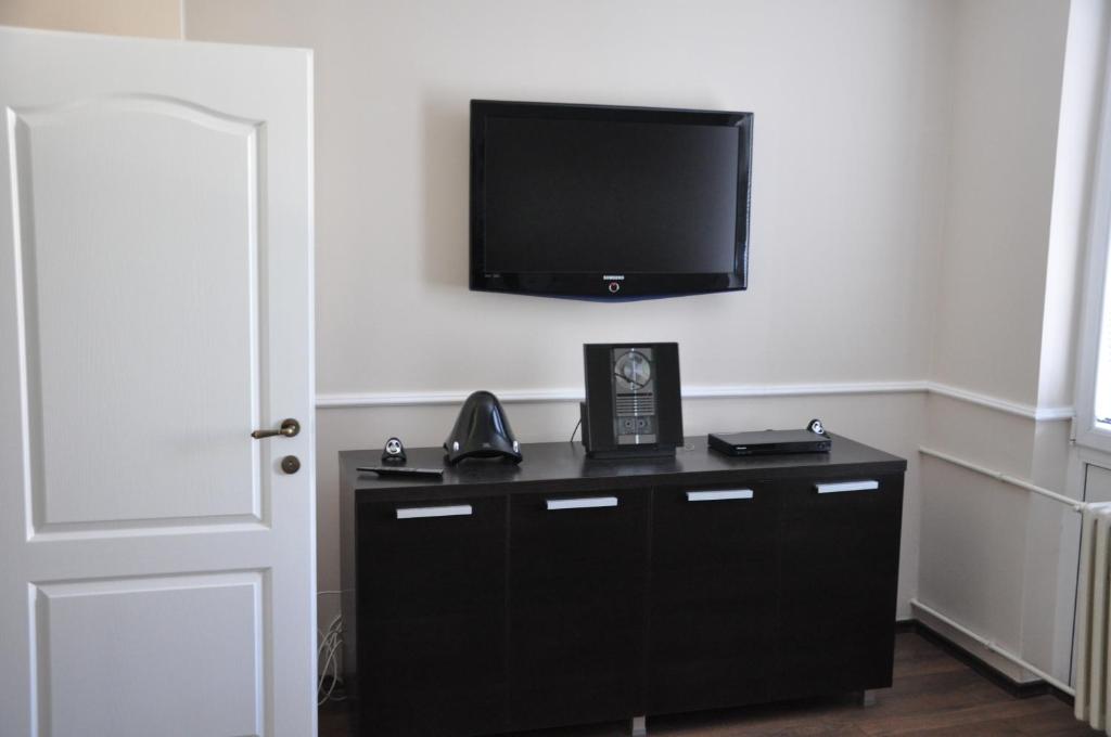 a room with a black dresser with a flat screen tv at Marko's Place Apartment in Skopje