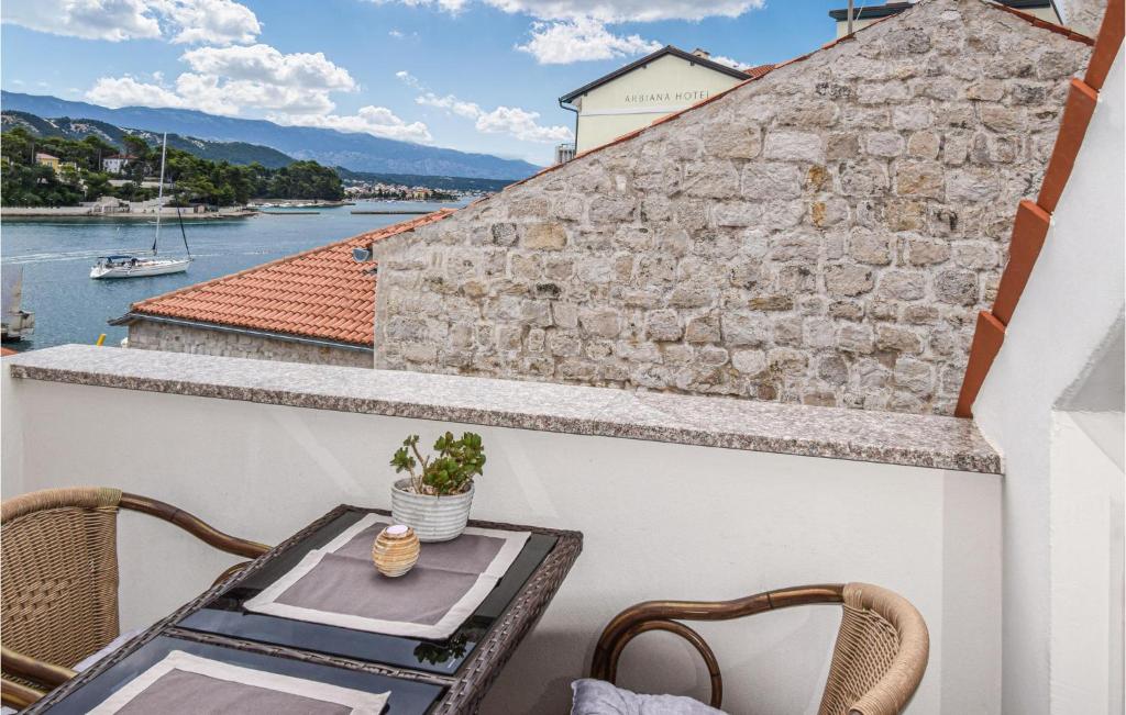 a balcony with a table and chairs and a view of the water at Awesome Home In Rab With Wifi And 3 Bedrooms in Rab