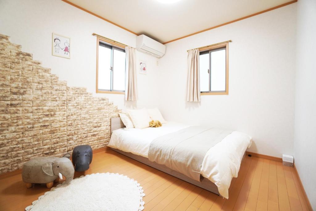 - une chambre avec un lit et un mur en briques dans l'établissement Miuranoyado, à Osaka