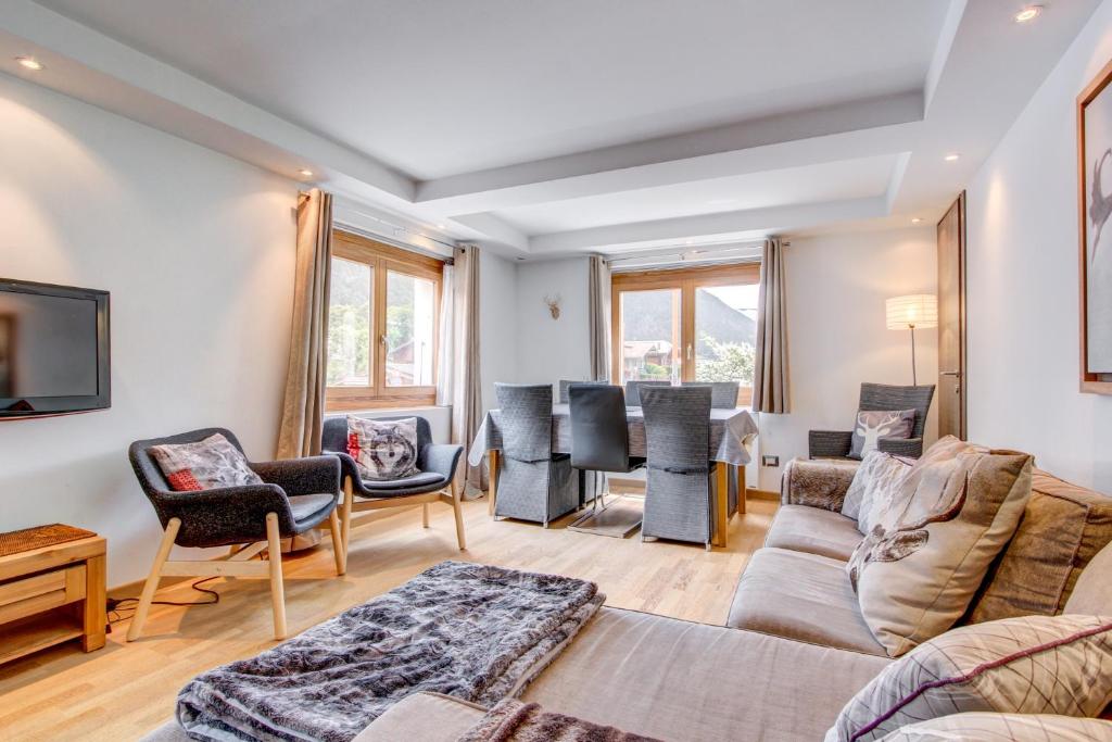 un salon avec un canapé, des chaises et une table dans l'établissement Les Berberis - Snow and Trek, à Morzine