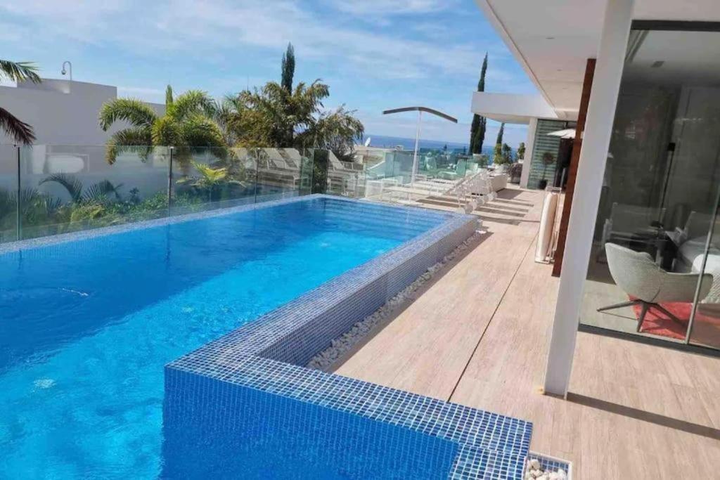 a swimming pool with blue water in a house at Luxury Villa Rebeka - Heated Pool and Jacuzzi in Adeje