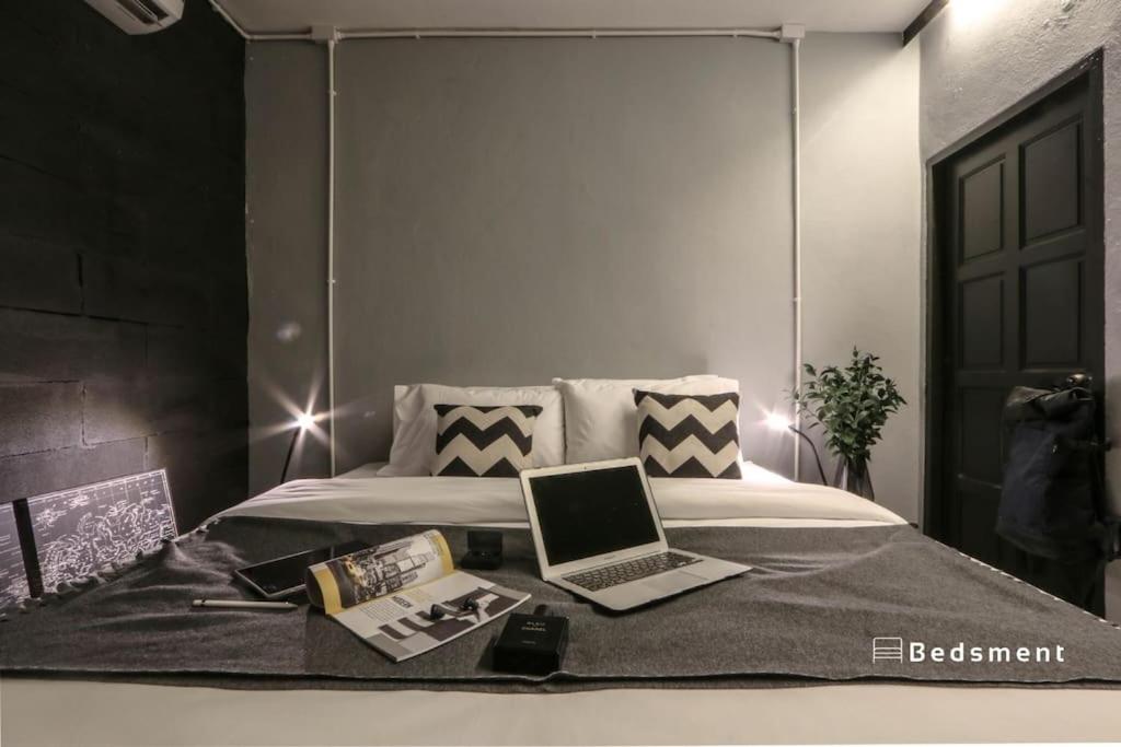 een slaapkamer met een bed met een laptop erop bij Bedsment@Hayaek in Chiang Rai