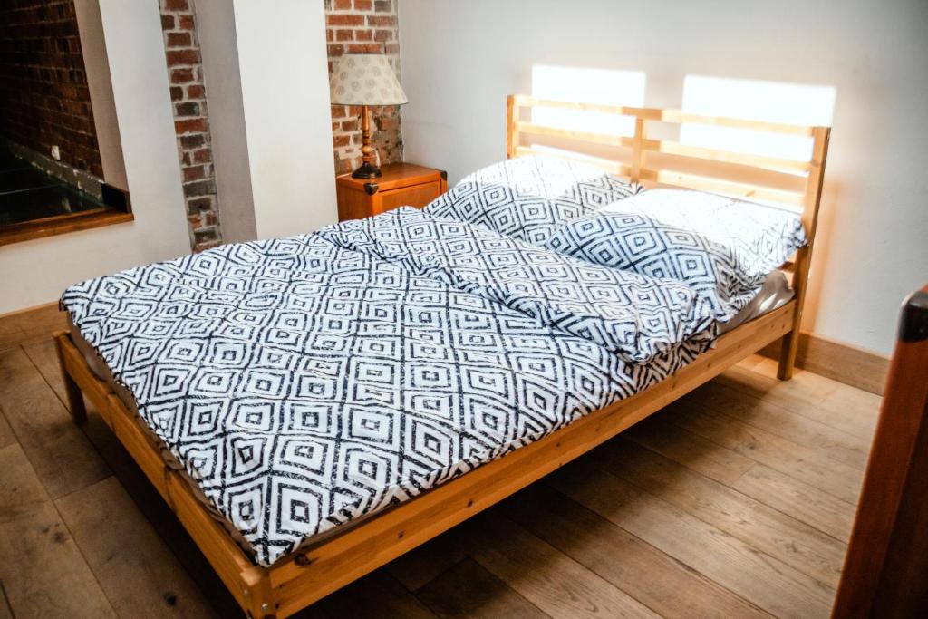 een bed in een slaapkamer met een houten bedframe bij RedCity Loft 25 in Żyrardów
