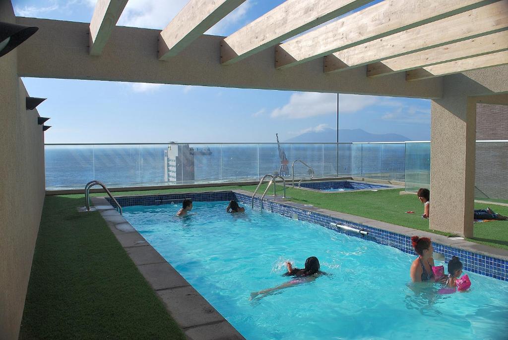 a group of people swimming in a swimming pool at Apartamento Virgilio Arias in Antofagasta