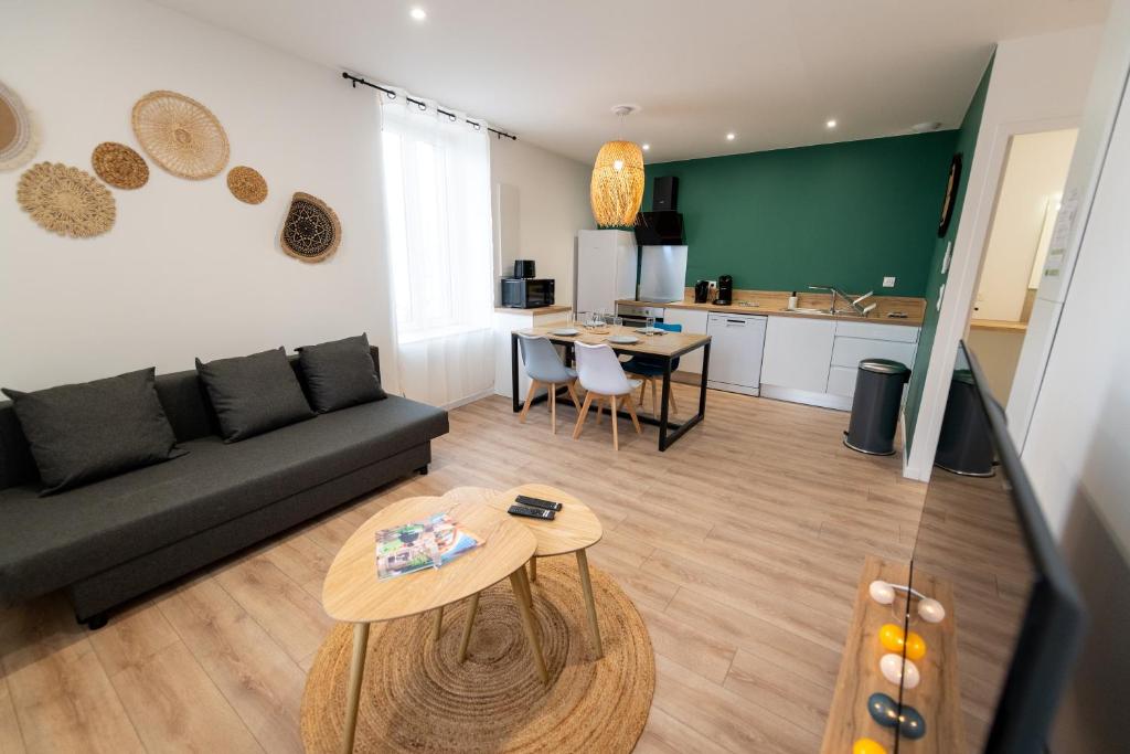 a living room with a couch and a table at KASA ZEN - Climatisation - Tout équipé - Stationnement gratuit in Saint-Chamond