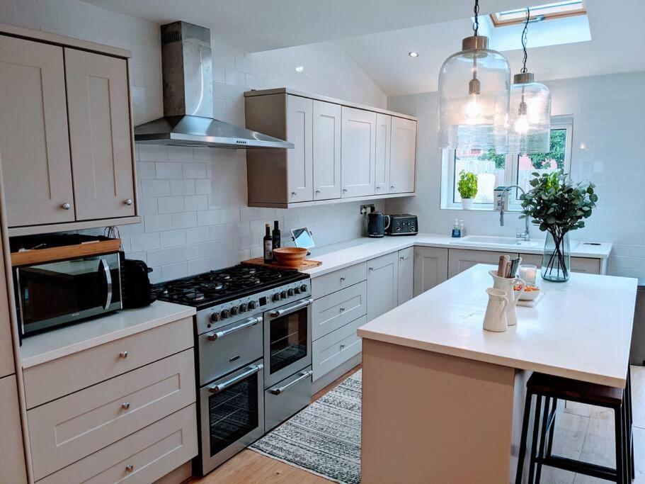 uma cozinha com armários brancos e um forno com placa de fogão em No.12 In The Heart Of Blackpool em Blackpool