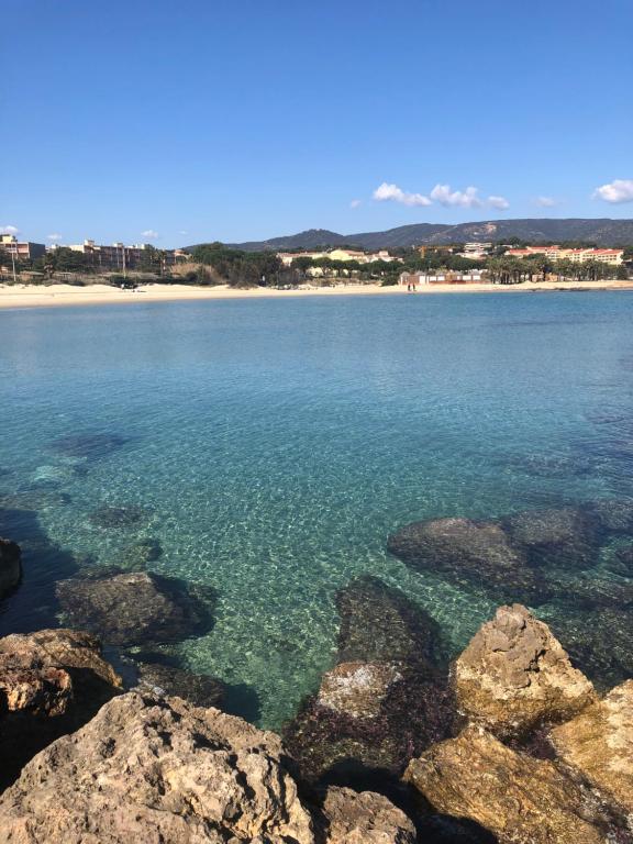 a view of a beach with rocks in the water at Résidence l’Amiraute in Bormes-les-Mimosas