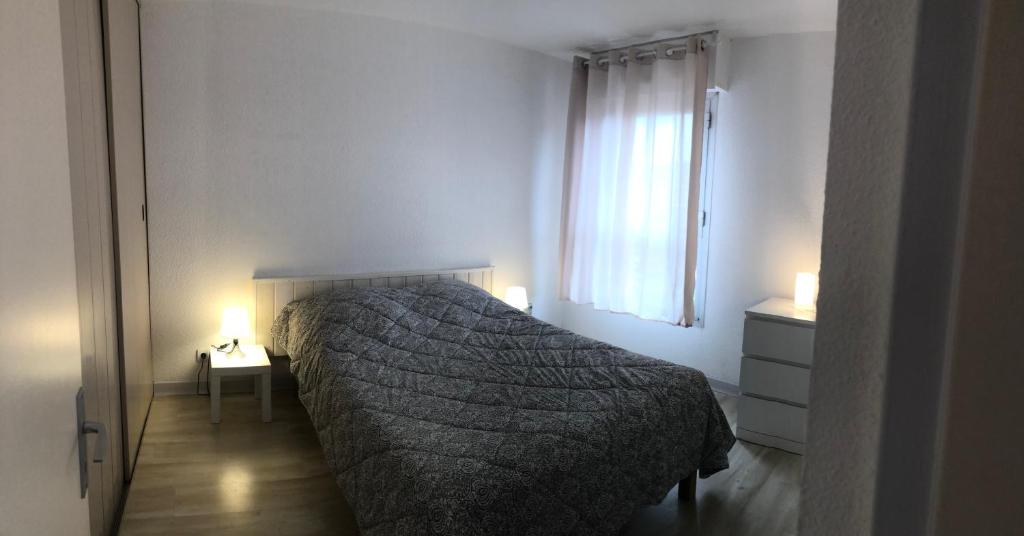 a bedroom with a bed and a window at Résidence l’Amiraute in Bormes-les-Mimosas