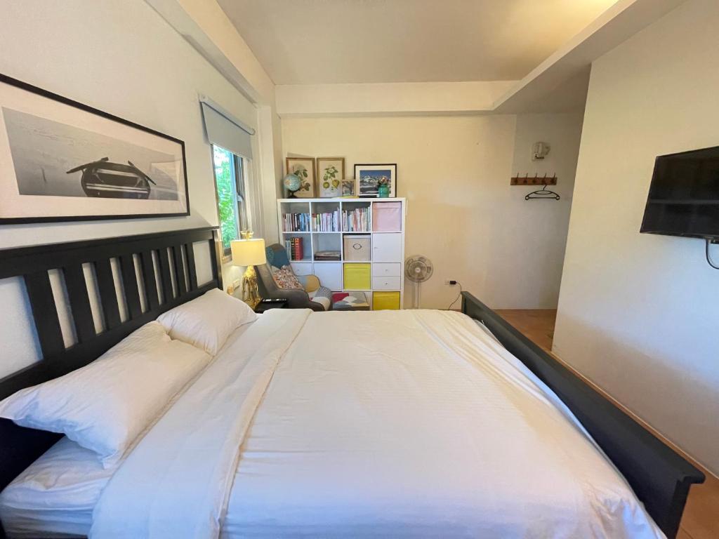 a bedroom with a large white bed and a chair at Star Wish B&amp;B in Dongshan