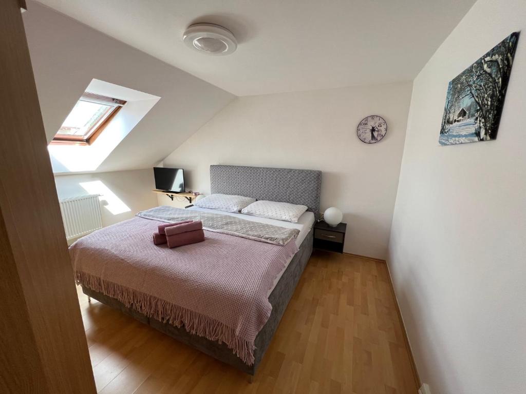 a bedroom with a bed and a clock on the wall at Ubytování u Novotných in Vyšší Brod