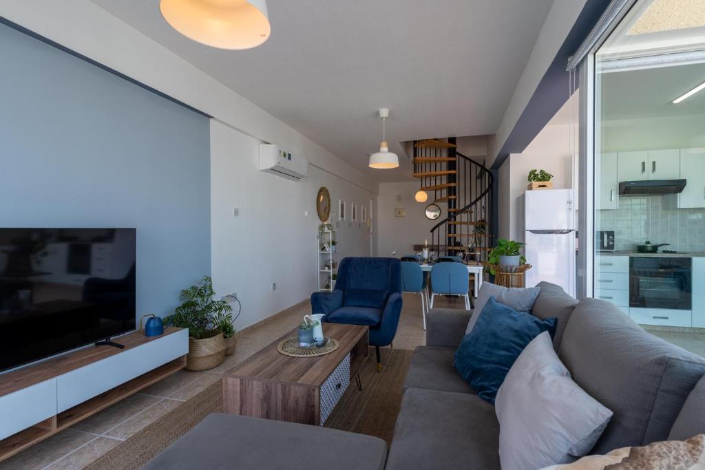 a living room with a couch and a tv at Chloris 3- Bedroom Apartment W/Pool in Larnaca in Larnaka