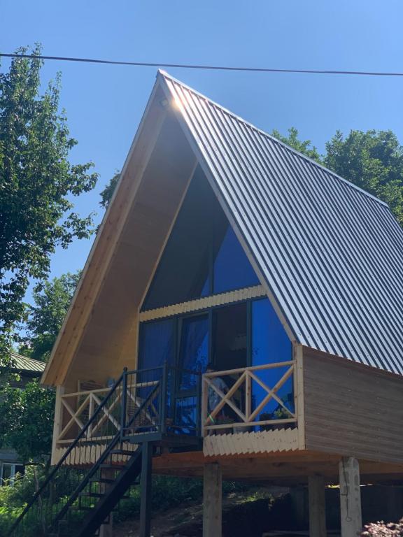 a large metal roof on a house with a porch at Eco house ketevani in K'obulet'i