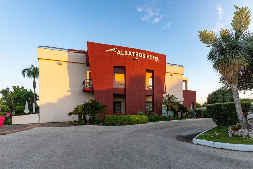 een gebouw met een bord dat leest aloha tropics hotel bij Albatros Hotel in Siracusa