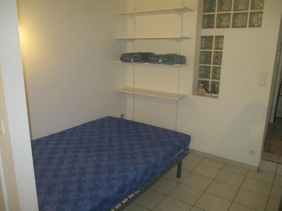 um quarto com uma cama com lençóis e prateleiras azuis em Plateau de 47 m2 Victoire - Marché des Douves em Bordeaux