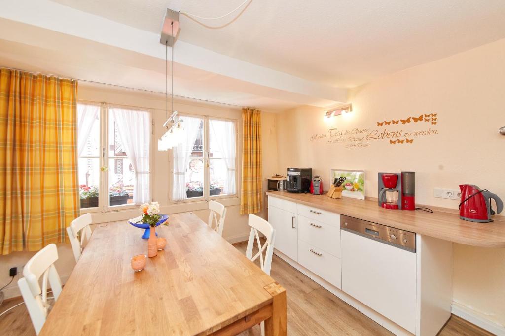 cocina con mesa de madera y armarios blancos en Ferienwohnung Altstadt, en Bernkastel-Kues