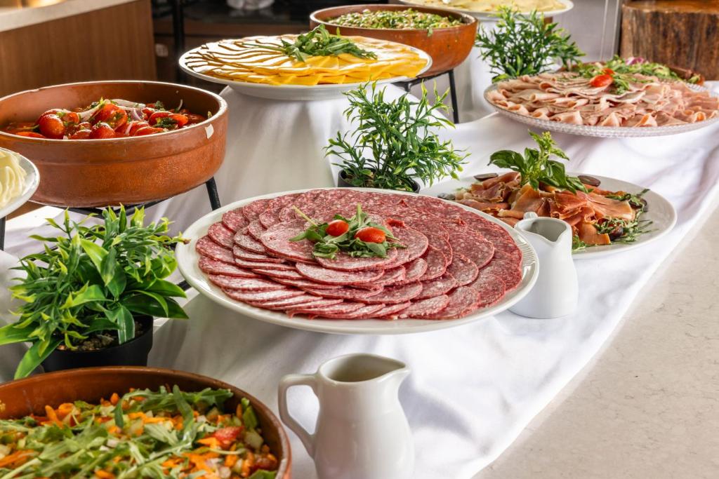 a table with many plates of food on it at Vivaldi Hotel in St. Julianʼs