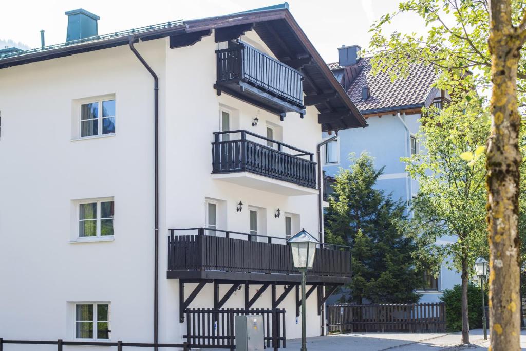 ein weißes Gebäude mit schwarzen Balkonen darauf in der Unterkunft Haus Wasmer by AlpenTravel in Bad Hofgastein