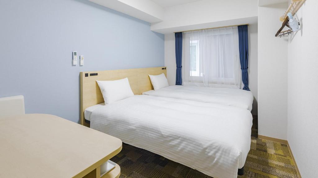 Кровать или кровати в номере Toyoko Inn Futamatagawa-eki Kita-guchi