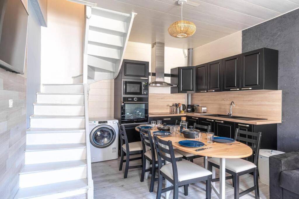 une cuisine avec une table et des chaises ainsi qu'un escalier dans l'établissement La Maison de Clara -Etretat Centre - 6 pers, à Étretat