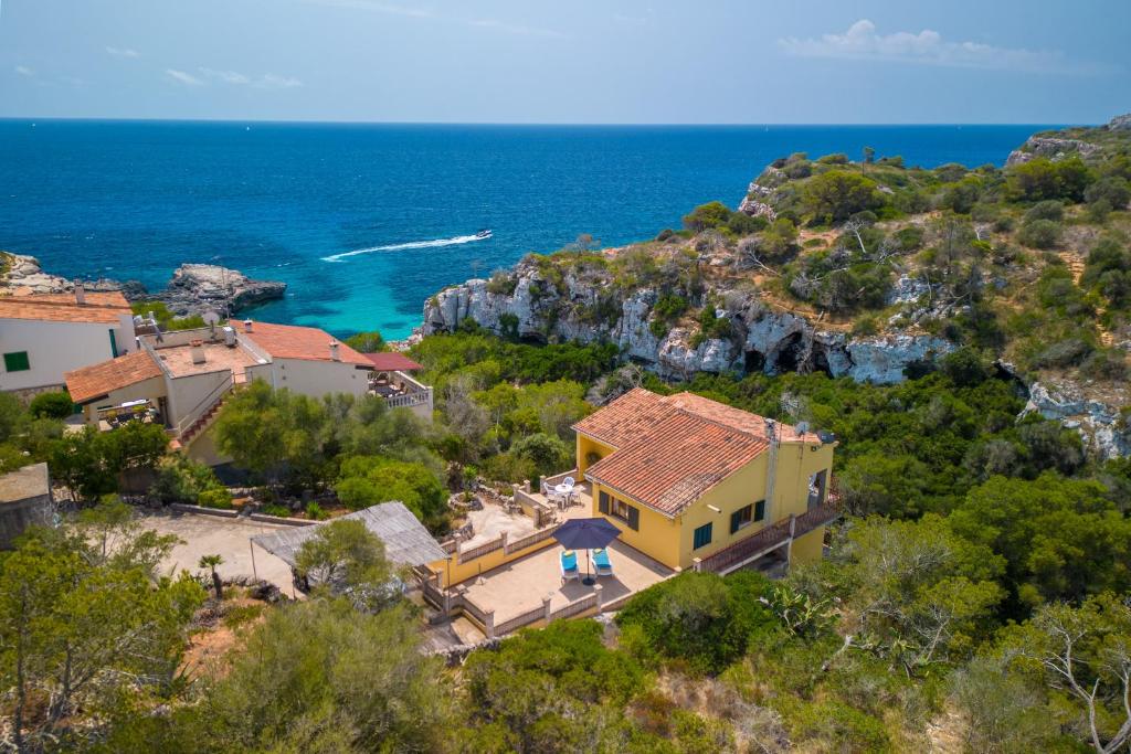 an aerial view of a house on a hill with the ocean at Ses Savines Beach cala Llombards in Santanyi