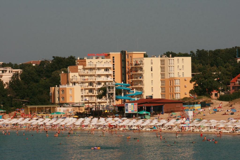 una playa con un montón de sombrillas y gente en el agua en Hotel Princess Residence en Kiten