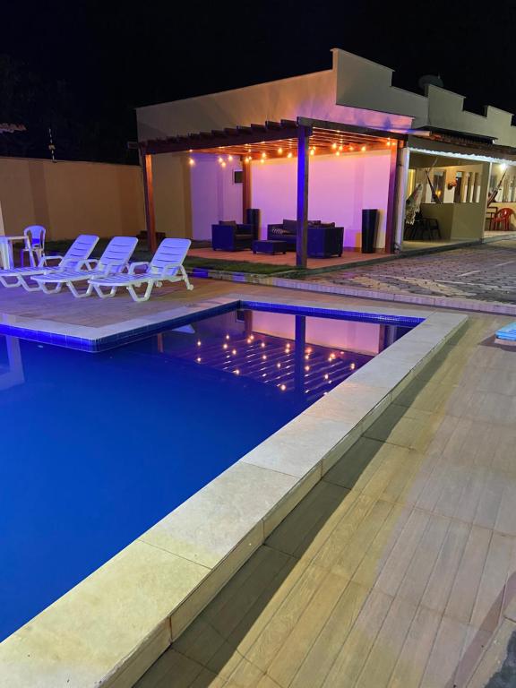 a swimming pool at night with chairs and a house at DUNAS RESIDENCE CASA 13 OU CASA 16 Santo Amaro - Lençóis Maranhenses in Santo Amaro
