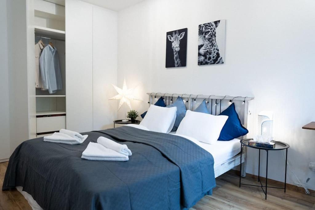 una camera da letto con un letto blu e bianco con asciugamani di Central Park Apartments a Brno