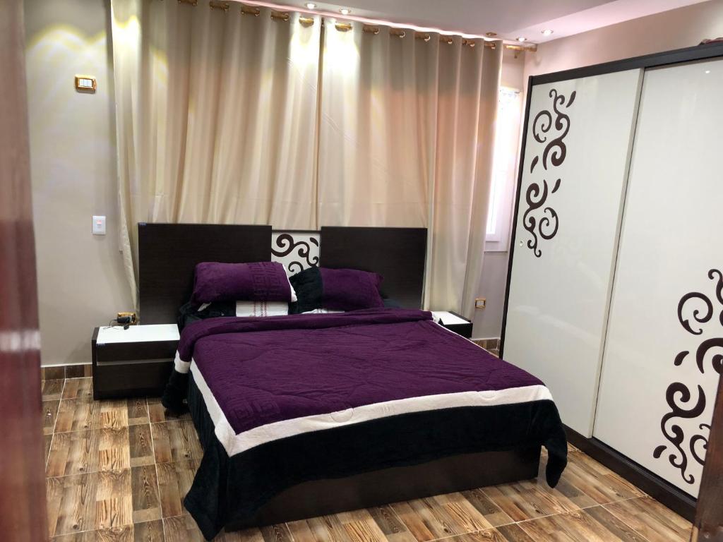 una camera con letto viola e cuscini viola di Senior chalet in Haciendabay for rent a El Alamein