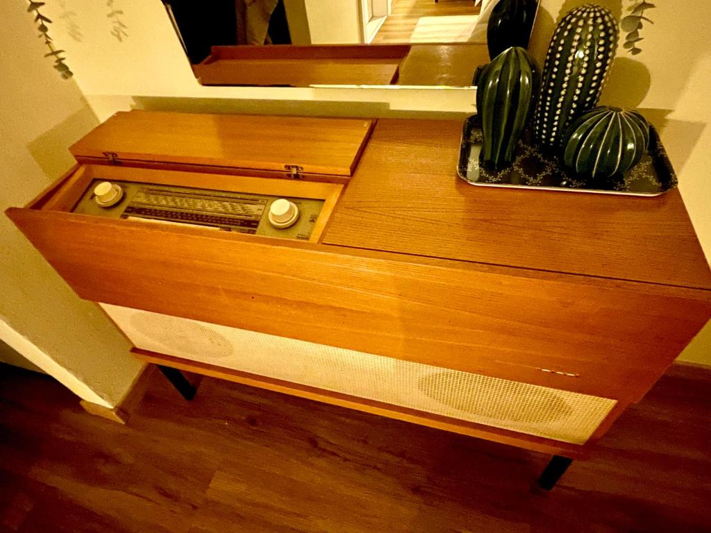 uma cómoda de madeira com um rádio e um espelho em Brunico 20 em Brunico