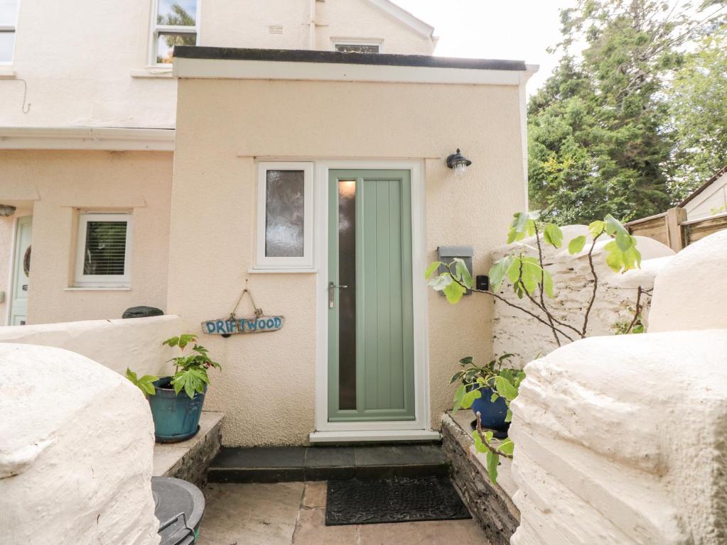 a house with a green door on the side of it at Driftwood in Dartmouth