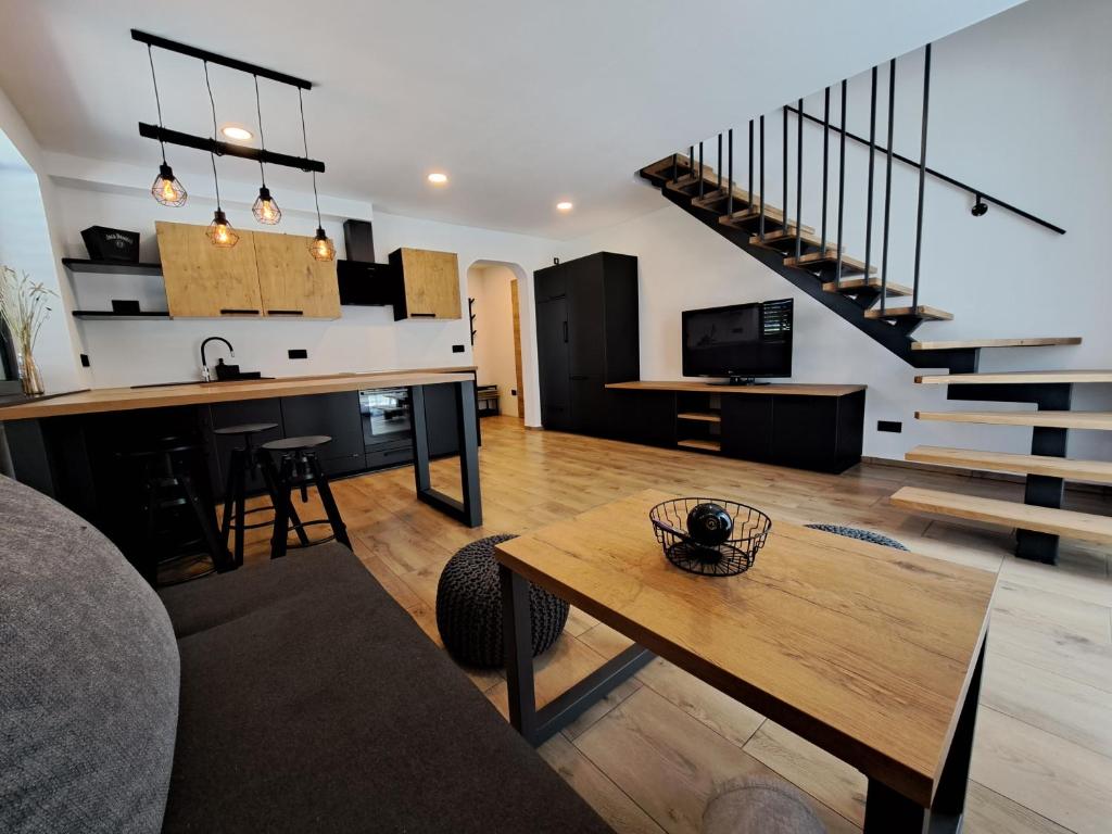 un soggiorno con tavolo, cucina e scale di Riverside Apartma 1, Kranjska Gora a Kranjska Gora