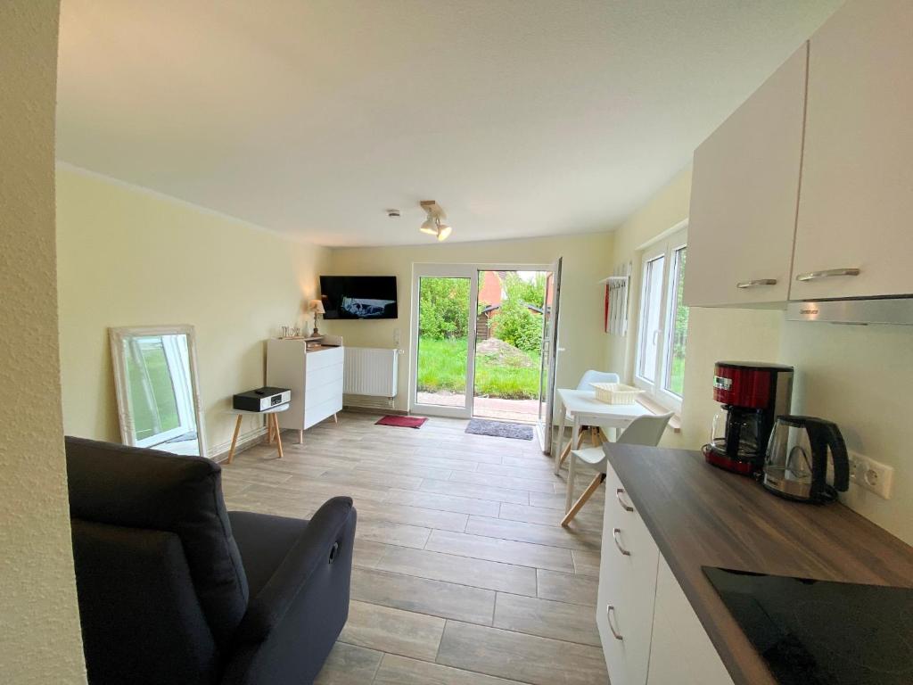 Una cocina y una sala de estar con un sofá y una mesa. en Am Oland 11 Bungalow, en Büsum