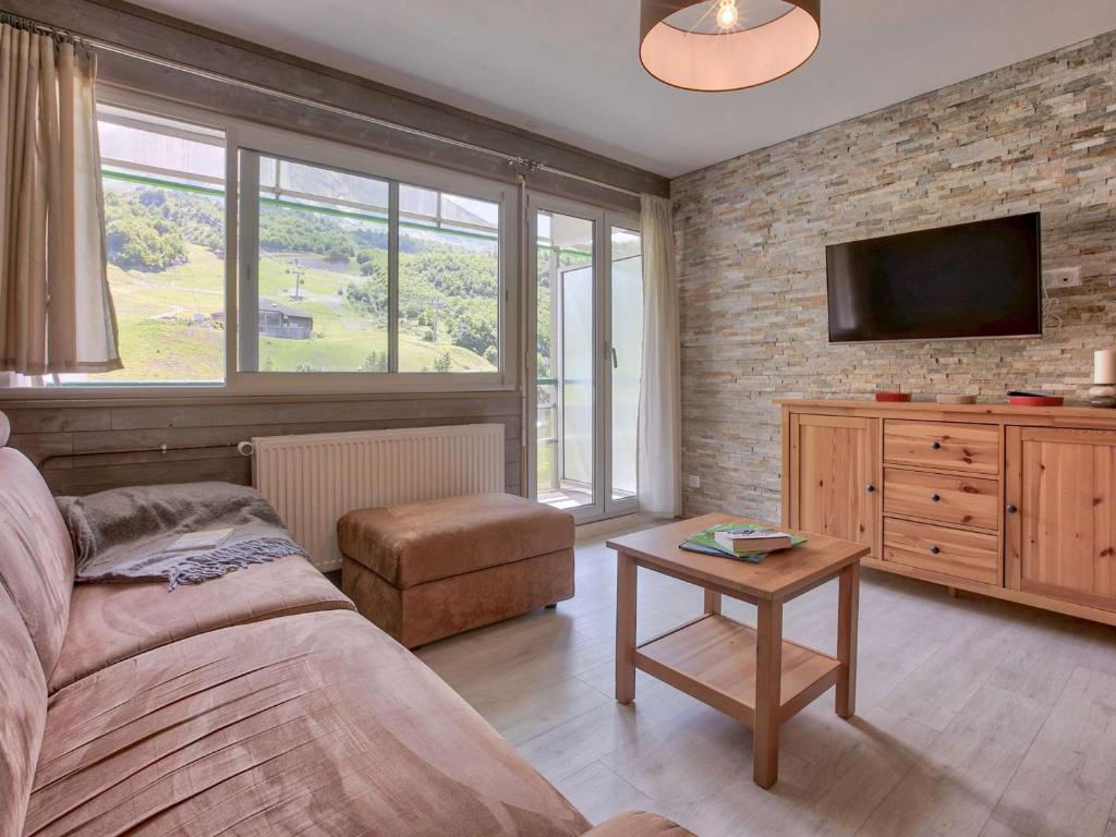 a bedroom with a bed and a tv on a brick wall at Appartement Gourette, 2 pièces, 6 personnes - FR-1-400-51 in Gourette