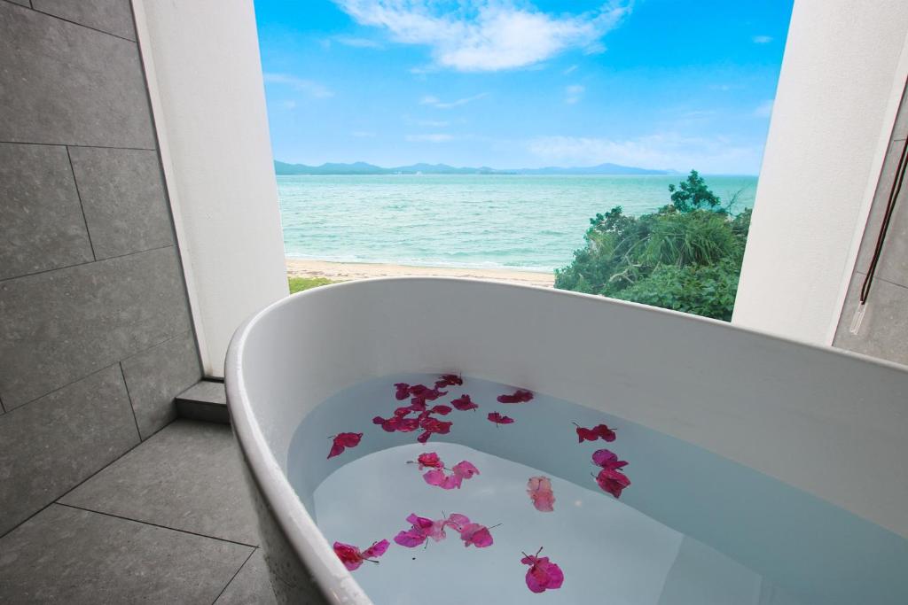 una bañera con flores delante de una ventana en Beach front studio -NagoNago- en Nago