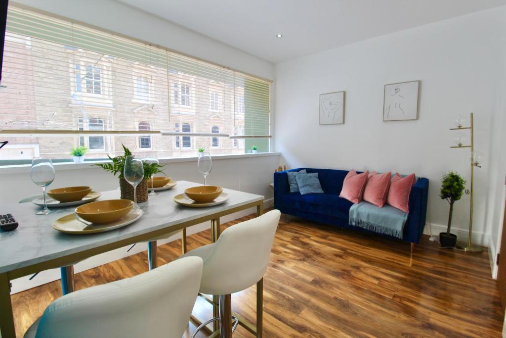 ein Wohnzimmer mit einem Tisch, Stühlen und einem Sofa in der Unterkunft Stunning Central City Apartment in Nottingham