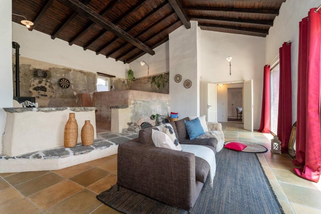 - un salon avec un canapé et une cheminée dans l'établissement Villa Mascali Nature & Relax - Affitti Brevi Italia, à Nunziata