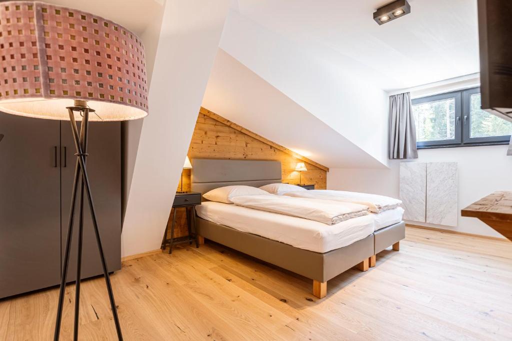 a bedroom with a bed and a lamp at Saalbach Suites by ALPS RESORTS in Saalbach-Hinterglemm