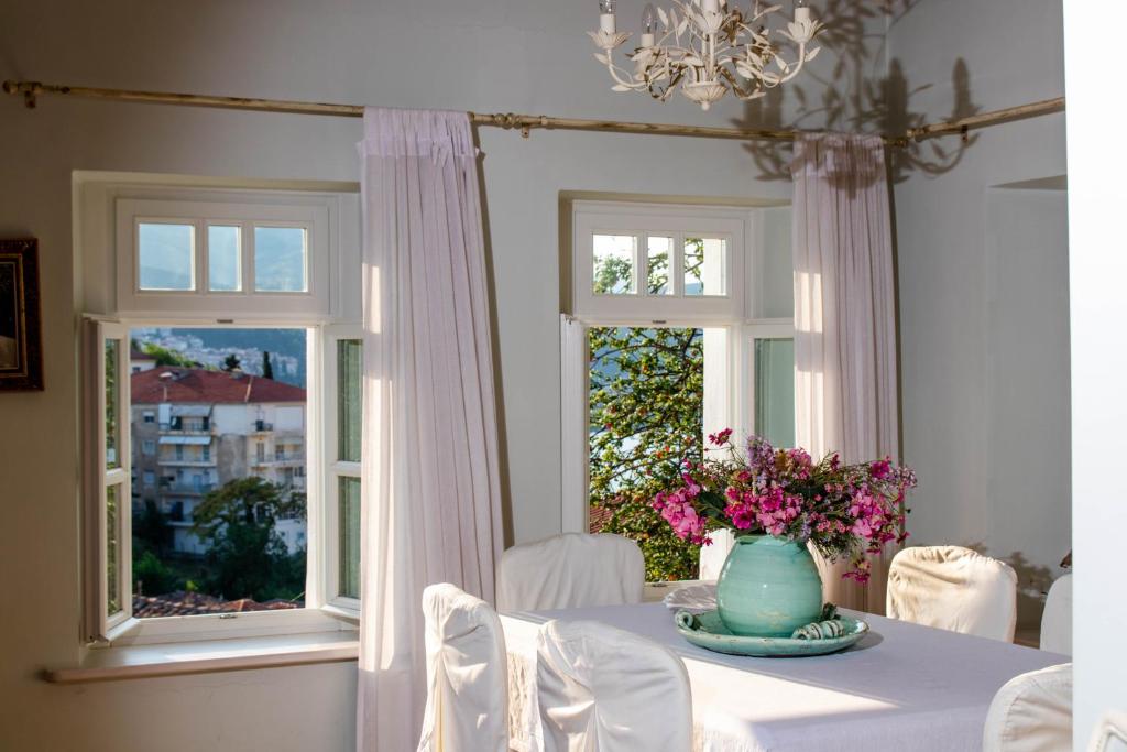 une salle à manger avec une table et un vase de fleurs dans l'établissement The Dream, à Kastoria
