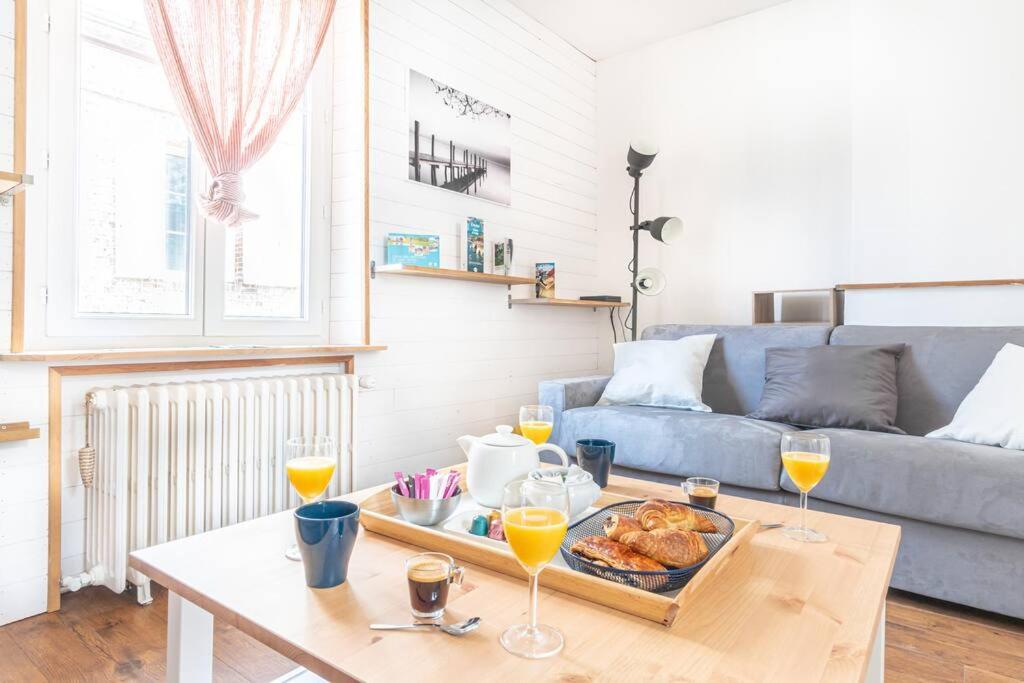 een woonkamer met een tafel en een dienblad met eten bij La Maison de Jade - Etretat Centre - 6 pers in Étretat