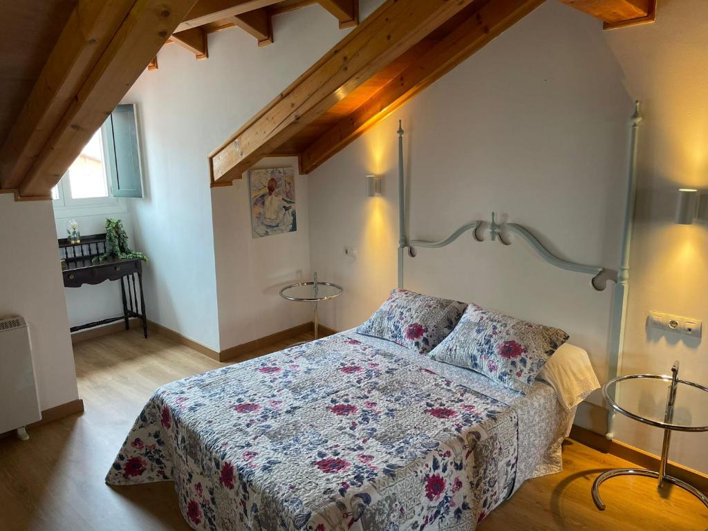 a bedroom with a bed with a floral bedspread at Agarimo das Burgas in Ourense
